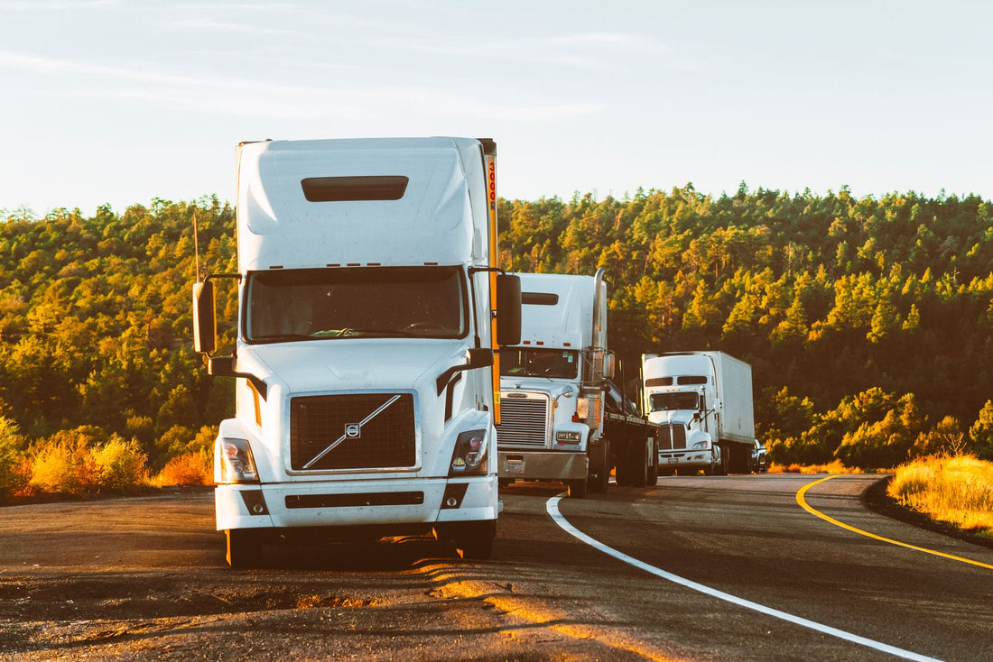 Semi trucks on a highway at golden hour - energy support for long-haul truck drivers