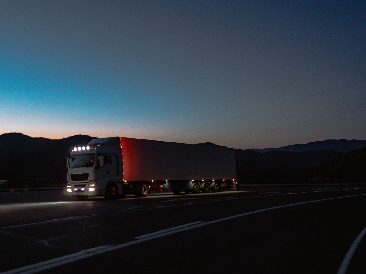 Large cargo truck driving on a highway at night - how to stay awake while driving at night for truck drivers