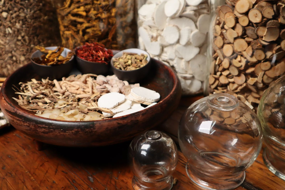 Wooden bowl of dried herbal roots beside glass jars of dried root slices on a warm wooden table - rhodiola rosea for fatigue