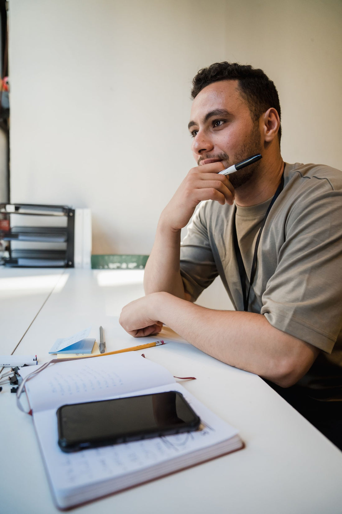 Office worker pondering at his desk in front of a computer - how to stay energized at work when you sit all day