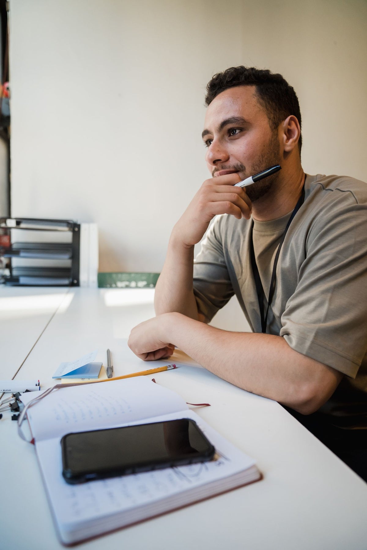 Office worker pondering at his desk in front of a computer - how to stay energized at work when you sit all day