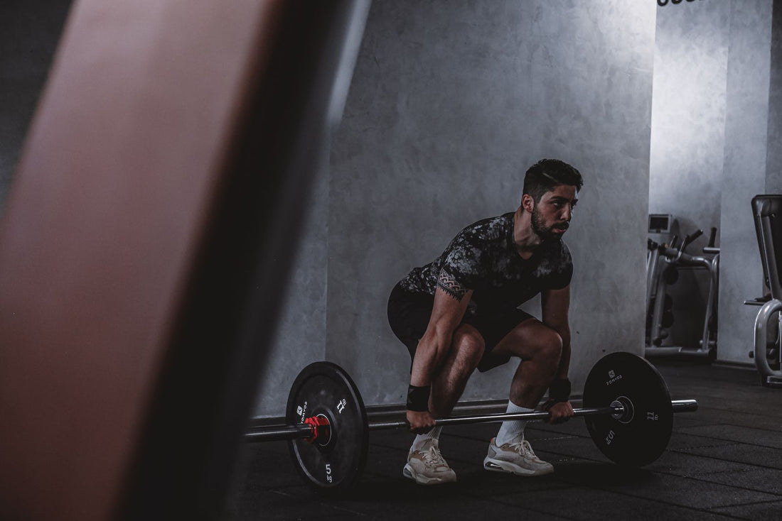 Athlete lifting a barbell in the gym - energy and focus for training on a busy schedule