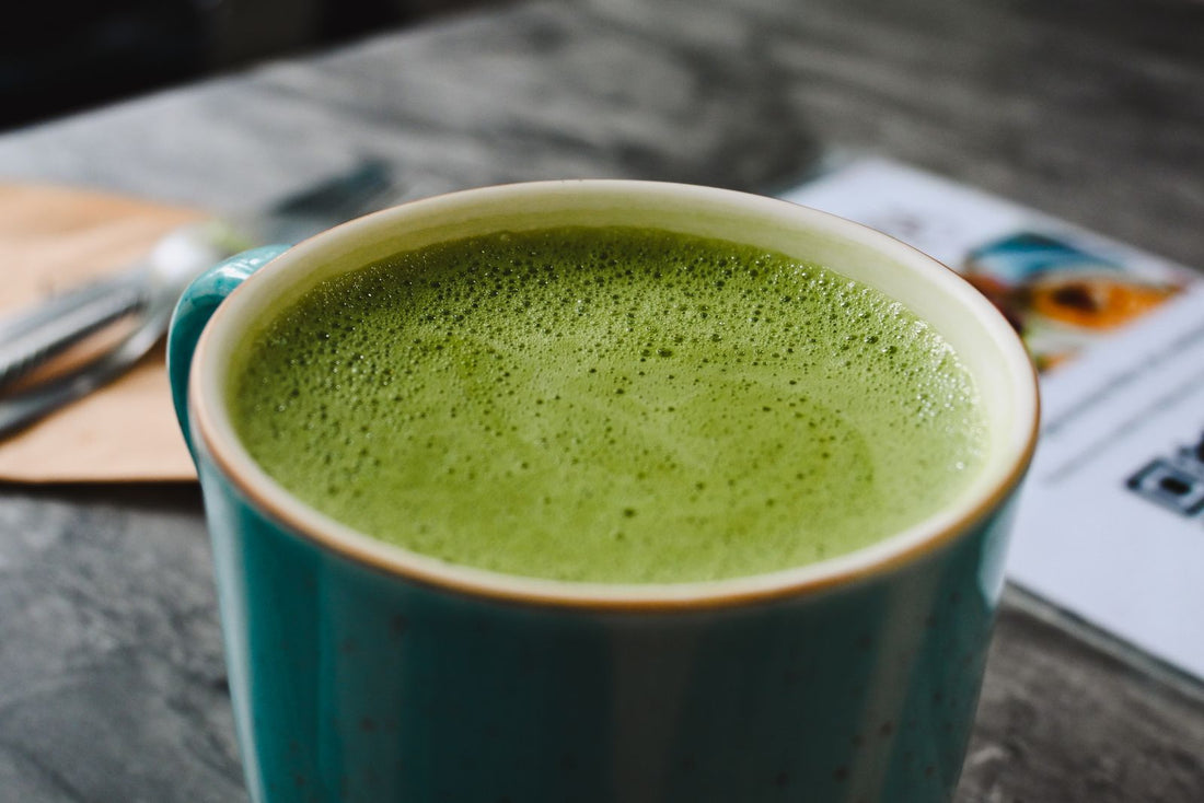 Hot matcha latte with frothy green tea in a ceramic cup - caffeine and L-theanine together from tea